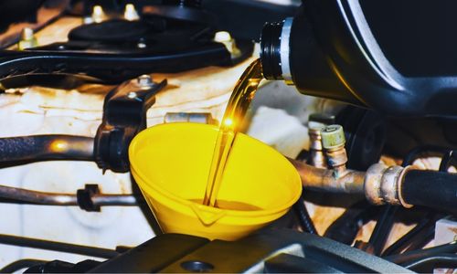 Original BPE routine-maintenance photograph showing oil being poured into an engine.